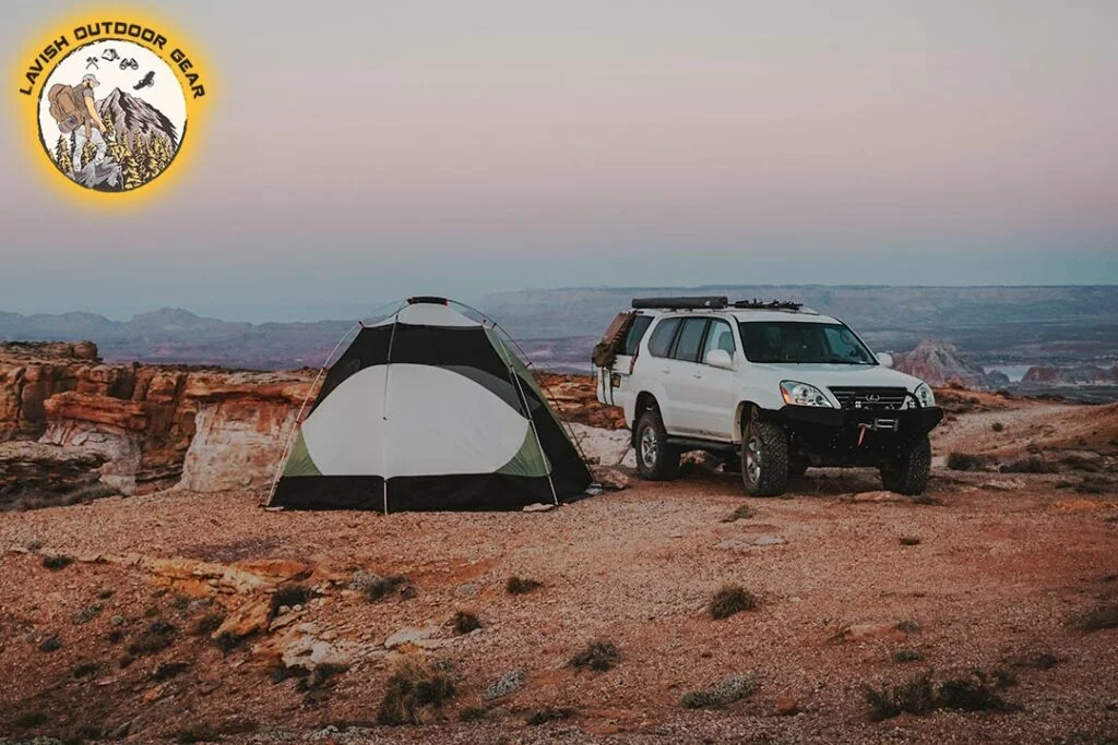 a tent is pitched with a car nearby