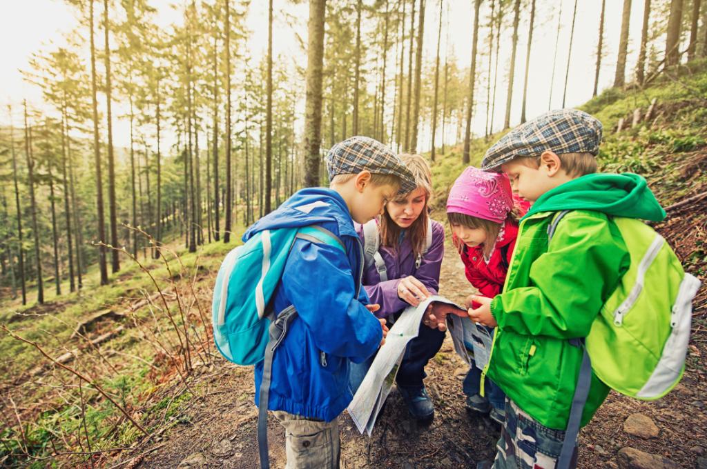 a mother and kids checking maps while backpacking